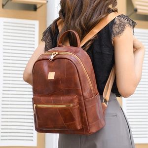 Detailed back view of a brown vintage leather backpack showing soft texture and stitching