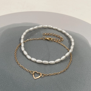 Dual-layer fashion bracelet set with white pearls and a golden hollow heart pendant