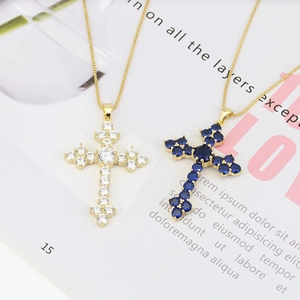 Detail of cross pendants with white and blue cubic zirconia on gold chains