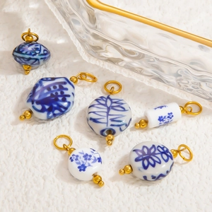 Detailed close-up of blue and white ceramic pendants with golden metal loops