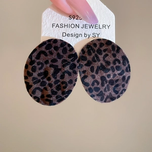 Close-up of leopard print oval stud earrings with flocked texture and S925 silver needles