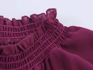 Détail du col smocké avec volants sur une robe longue en mousseline rouge bordeaux