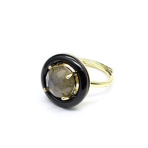 Detail of an adjustable gold ring with a grey faceted gemstone and black halo detail