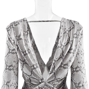 Detailed back view of snakeskin print dress featuring deep V back and ruched fabric