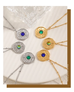 Detail of sunburst coin necklaces with colorful crystals in a ceramic tray