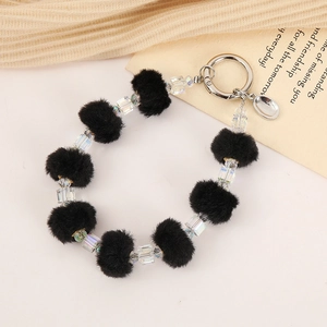 Detail of plush faux fur pompom keychain with iridescent crystal beads and silver ring