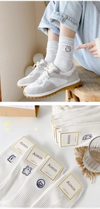 Close-up of white combed cotton socks with cute cartoon animal embroidery and stripes