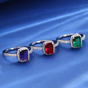Vintage style square zircon rings in purple, red, and green on elegant blue silk fabric