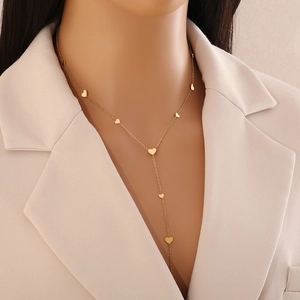 Detail shot of a golden heart Y-shaped titanium steel necklace on a model's neck