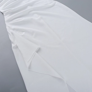 Detailansicht des weißen Kleides mit plissiertem Stoff und elegantem Schlitz-Design am Saum