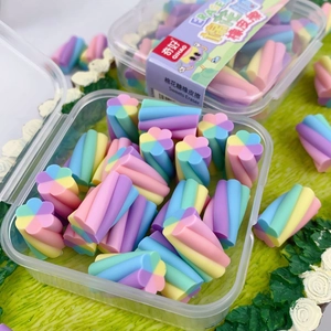 Close-up of colorful marshmallow shaped erasers in a clear storage box on a green mat