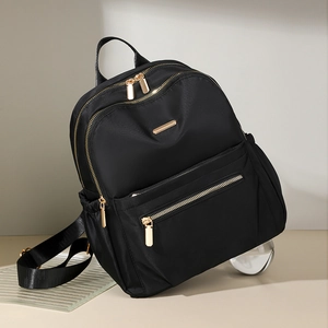 Detail of waterproof black nylon backpack with golden zippers and high-end texture