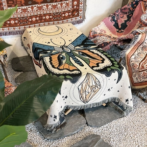 Detail showing bohemian woven blanket with butterfly, moon patterns and fringe edges