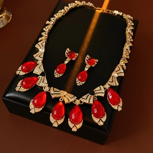 Close-up of vintage jewelry set featuring red teardrop stones and rhinestone bows