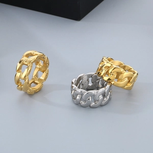 Macro detail of three punk-style stainless steel Cuban chain rings in gold and silver