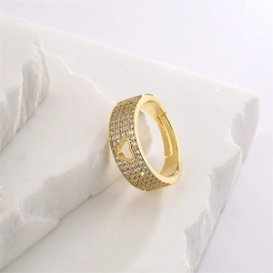 Macro detail of gold plated heart ring with micro-pave cubic zirconia on a stone surface