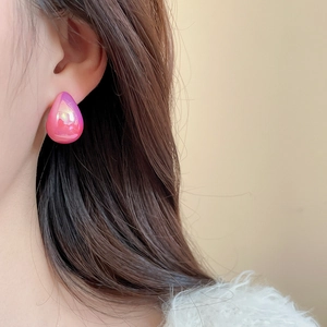 Detail of iridescent pink teardrop stud earring showing shimmering gradient finish