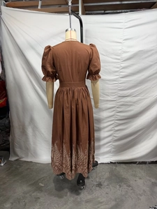 Vue détaillée de la robe longue marron avec taille haute et broderies de feuilles