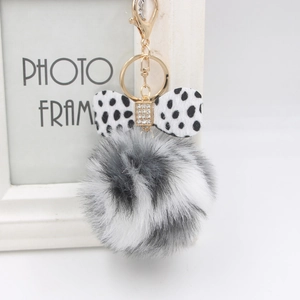 Chic keychain with fluffy grey faux fur pom pom and black spotted dalmatian bow tie