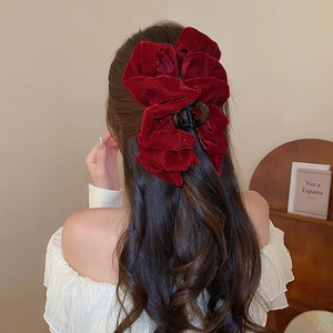 Detailed view of a red velvet bow hair clip worn elegantly on the back of the head