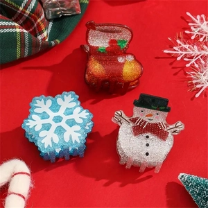 Detailed view of Christmas hair claws featuring snowman, stocking and snowflake designs