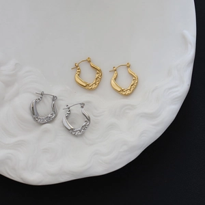 Detailed macro of vintage chain link and hammered texture gold and silver hoop earrings