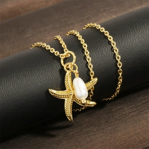 Macro detail of 18K gold-plated starfish pendant with a white baroque pearl on silk