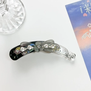 Detail of elegant large banana hair clip with smoke grey crystals and floral decoration