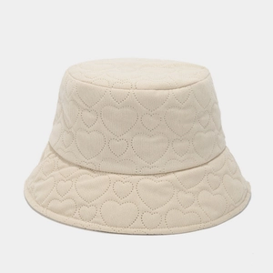Close-up of beige corduroy bucket hat featuring detailed heart-shaped quilted stitching
