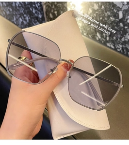 Detail of oversized silver metal frame sunglasses with gray gradient lenses