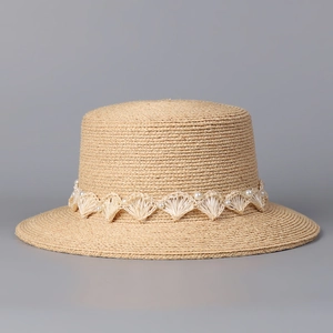 Détail du chapeau de paille avec bordure en dentelle élégante et petites perles blanches