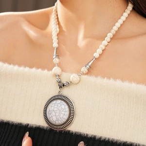 Detail of bohemian stone beaded necklace with vintage marble pendant and silver spacers