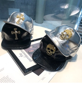 Detail of hip hop faux leather baseball caps with metal cross and skull decorations
