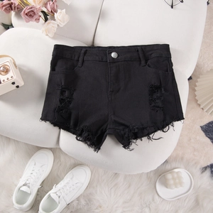 Flat lay of black distressed denim shorts with ripped details and casual lifestyle props