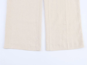 Gros plan détaillé de l'ourlet du pantalon en lin beige montrant la texture du tissu