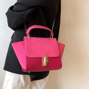 Magenta wings handbag with crocodile texture and gold chain strap on model