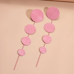 Detail view of pink geometric tiered drop earrings with textured circular patterns