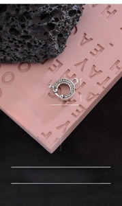 Macro detail of silver-plated copper lobster clasp with engraved motivational text