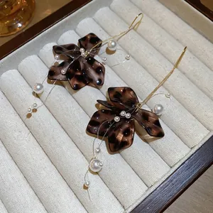 Vintage leopard acrylic flower earrings with pearls and gold hooks in a jewelry box