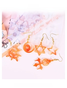 Macro detail of silicone mold for star and moon resin earrings with finished orange charms