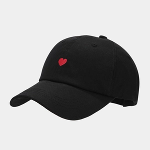Detailed close-up of a black baseball cap featuring a red heart embroidery on twill cotton