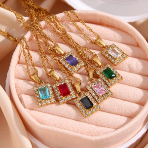 Detail of colorful rectangular zircon pendants with golden twist chain in pink velvet box