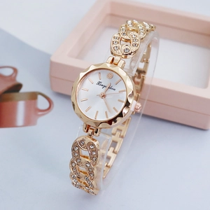 Close-up of gold chain bracelet watch with crystal inlay and minimalist round dial