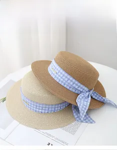 Detail of two straw sun hats with blue heart pattern bow ribbons and golden logos