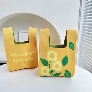 Knitted sunflower tote bags with YOU ARE MY SUNSHINE text and floral patterns on table