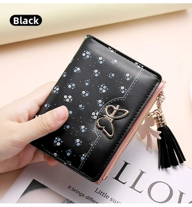 Detail of black floral wallet with gold butterfly clasp and pink zipper detail