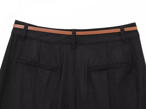 Detail of linen blend black trousers with a slim brown belt and dual back pockets
