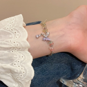 Close-up of colorful crystal bead bracelet with purple enamel butterfly and heart zircon charm