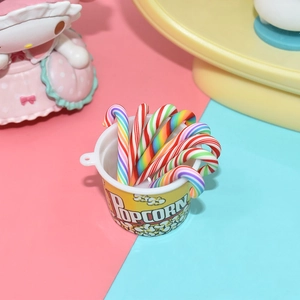 Miniature yellow popcorn bucket with colorful polymer clay candy canes for DIY crafts