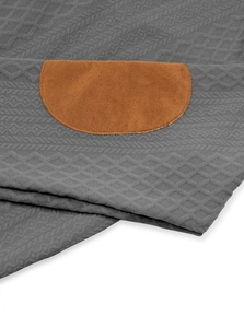 Macro detail of men's long sleeve shirt showing dark grey jacquard texture and brown suede patch